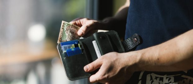 Człowiek trzymający portfel i pieniądze