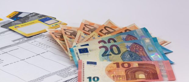 Banknoty euro ułożone na dokumentach finansowych i formularzu wniosku.