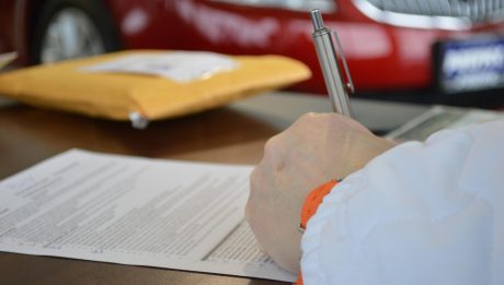 Podpisywanie dokumentu kredytowego długopisem przy biurku.