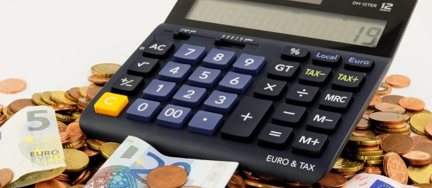 Kalkulator leżący na monetach i banknotach euro.