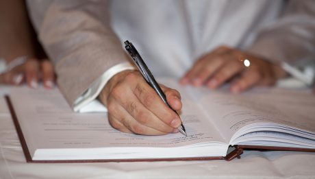 Osoba podpisująca dokument umowy pożyczki długopisem przy stole