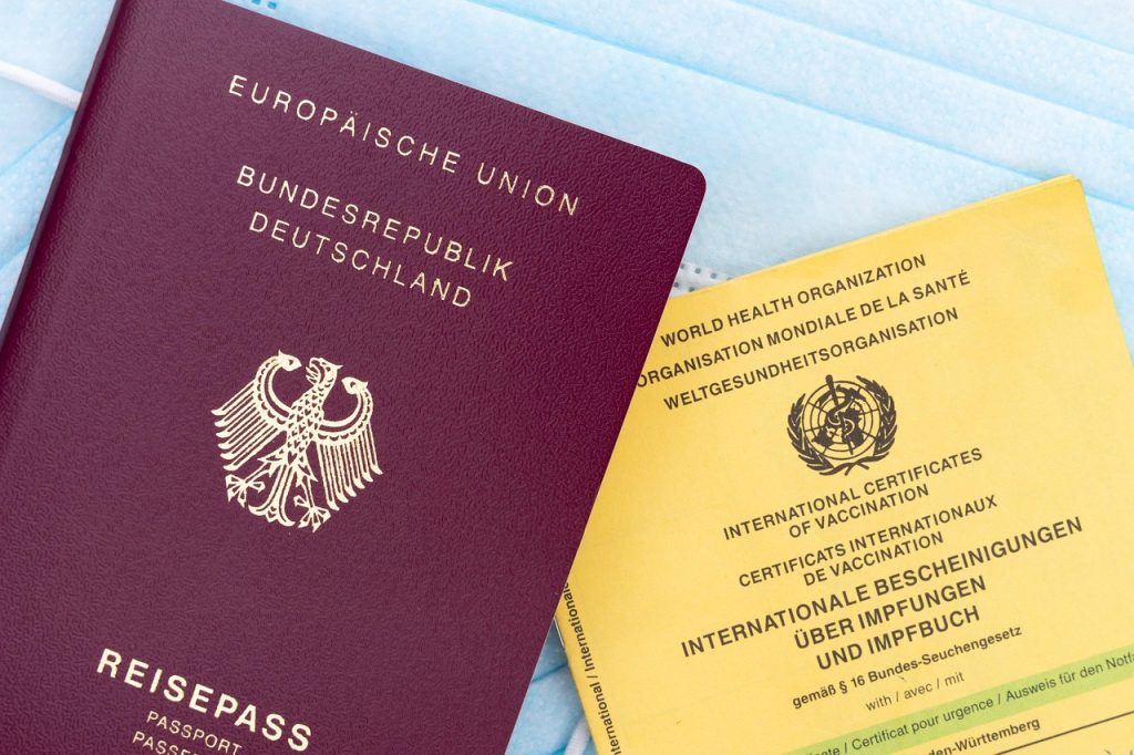 Paszport i dokumenty tożsamości leżące obok siebie na jasnym blacie.