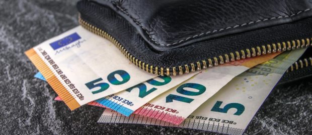 Skórzany portfel z banknotami euro wystającymi z zamka błyskawicznego.